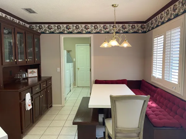 a view of a dining room and chandelier fan windows and wooden floor