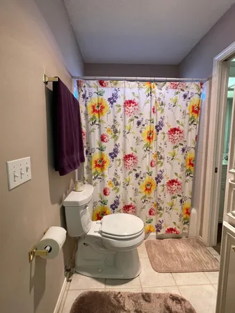 a bathroom with a toilet and a shower curtain