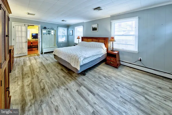 a bedroom with a bed and wooden floor
