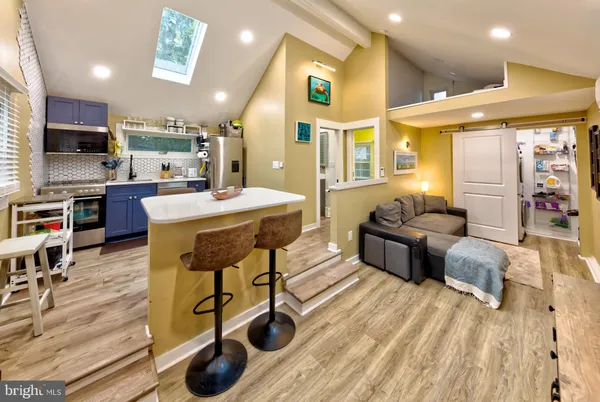 a living room with furniture a flat screen tv and kitchen view