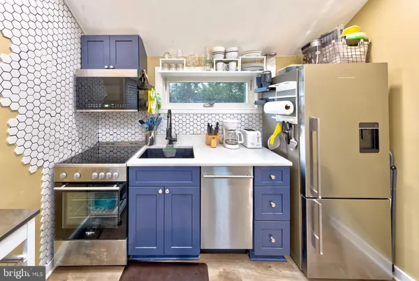 a kitchen with a refrigerator a stove and wooden floor