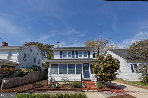 a front view of a house with yard and green space