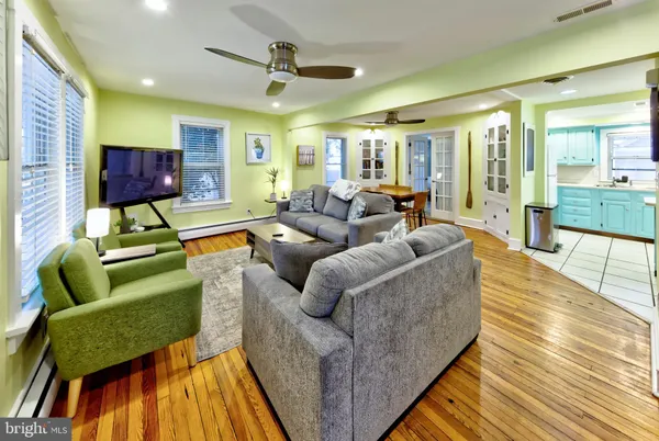 a living room with furniture and a wooden floor