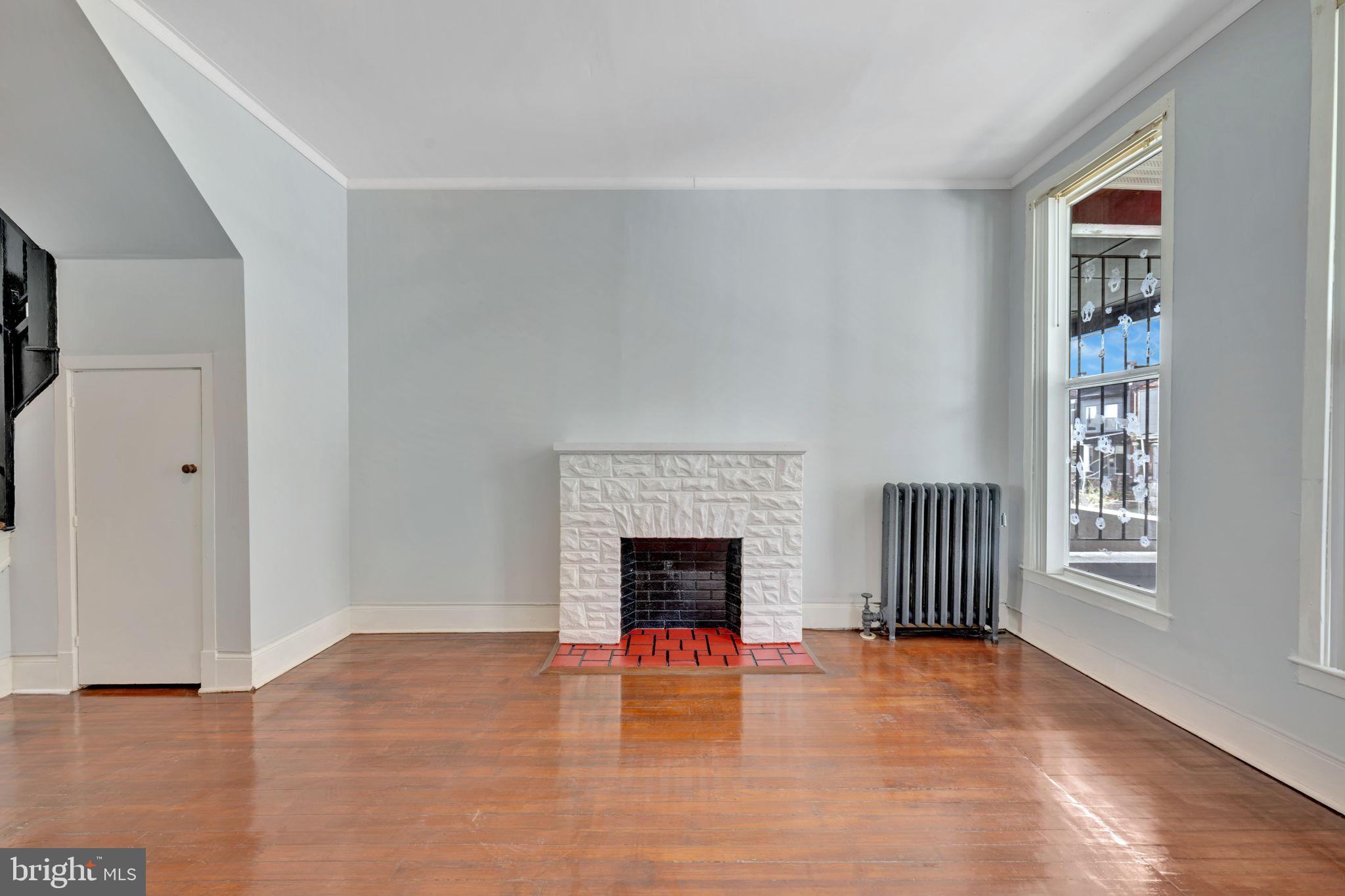 2822 Riggs Avenue Baltimore, MD 21216 - Photo 6 of 30 an empty room with furniture and fireplace