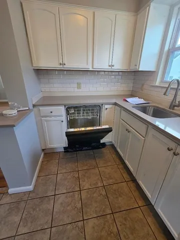 a kitchen with a sink a stove and cabinets
