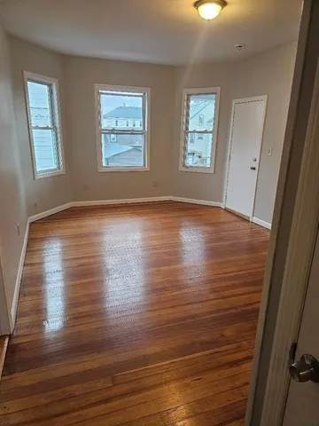 a view of room with window and wooden floor