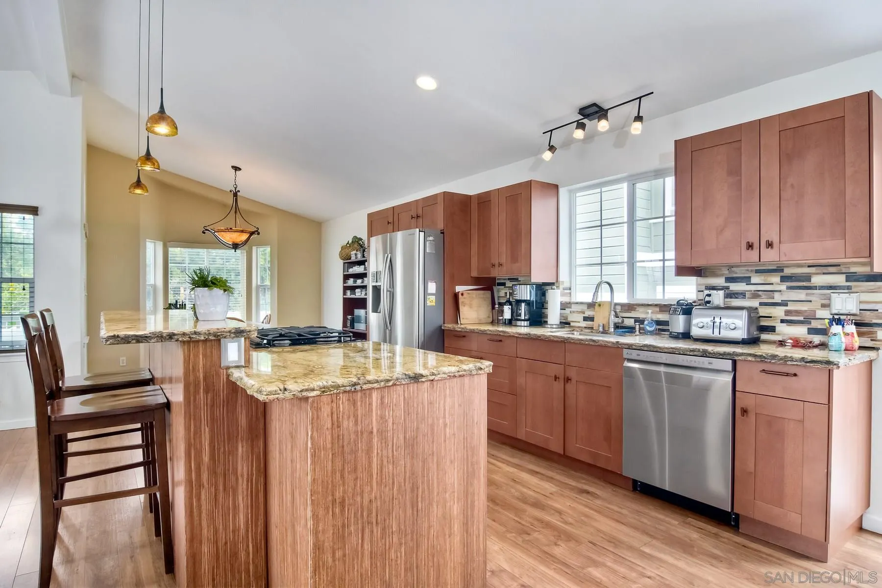 1245 Windsor Road Encinitas, CA 92007 - Photo 9 of 25 a kitchen with stainless steel appliances granite countertop a stove top oven a sink dishwasher and white cabinets with wooden floor