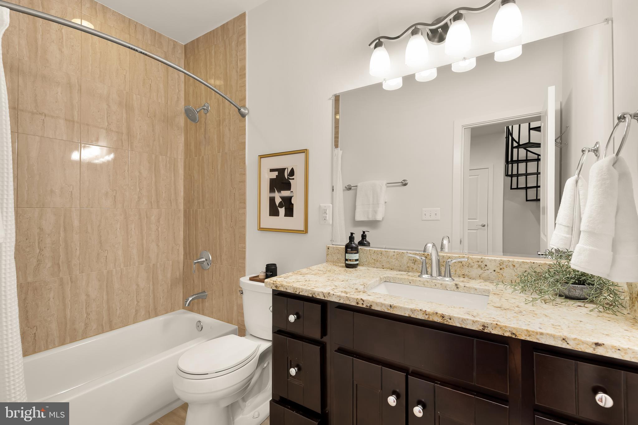 1350 Perry Place Northwest Washington, DC 20010 - Photo 30 of 53 a bathroom with a granite countertop sink a toilet and a mirror