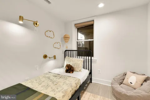 a bedroom with a bed and a painting on the wall