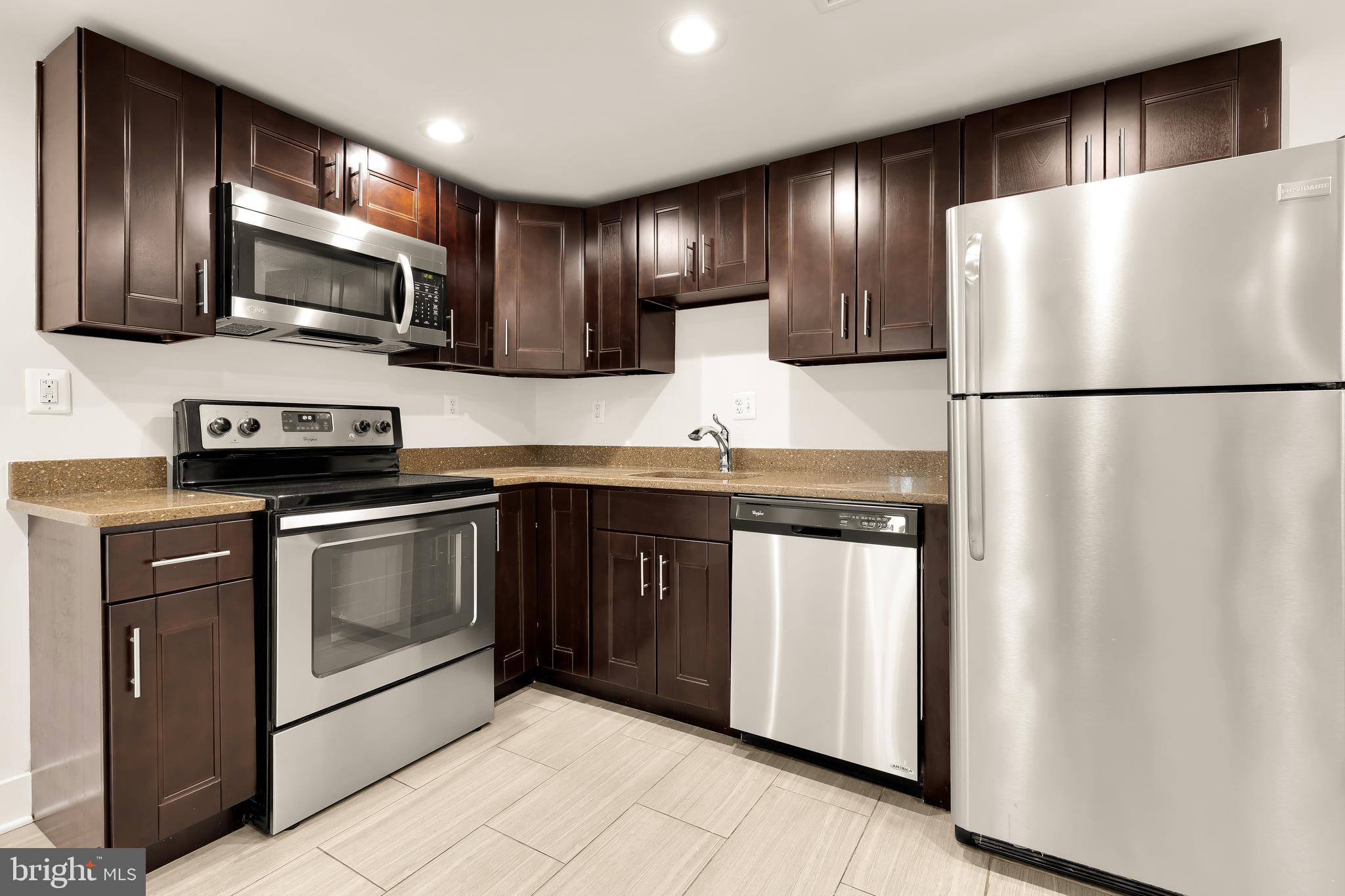 1350 Perry Place Northwest Washington, DC 20010 - Photo 41 of 53 a kitchen with stainless steel appliances granite countertop a refrigerator a stove a sink and a microwave