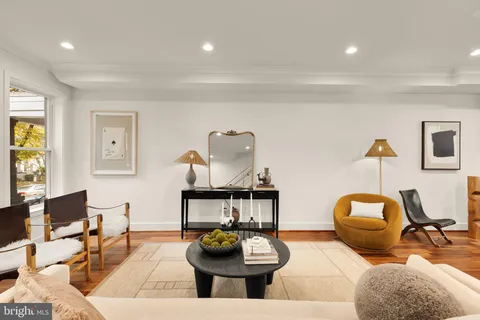 a living room with furniture a rug and wall painting