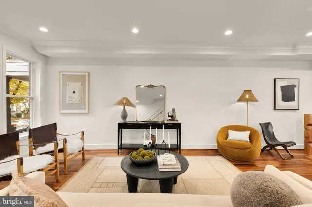 a living room with furniture a rug and wall painting