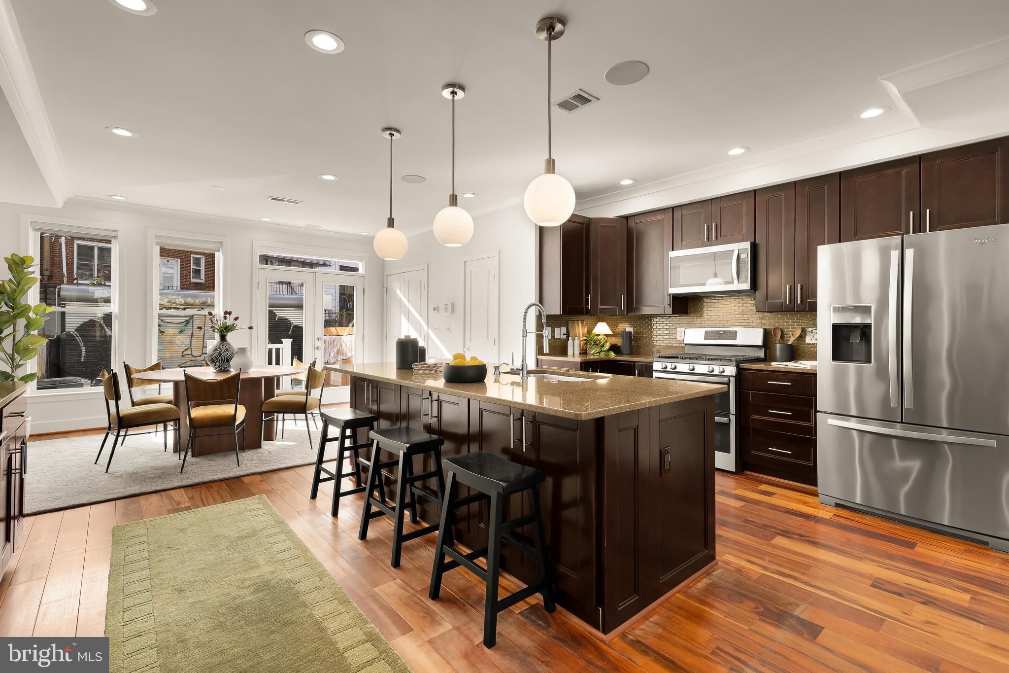 1350 Perry Place Northwest Washington, DC 20010 - Photo 9 of 53 a kitchen with stainless steel appliances granite countertop a refrigerator a stove a sink a dining table and chairs with wooden floor