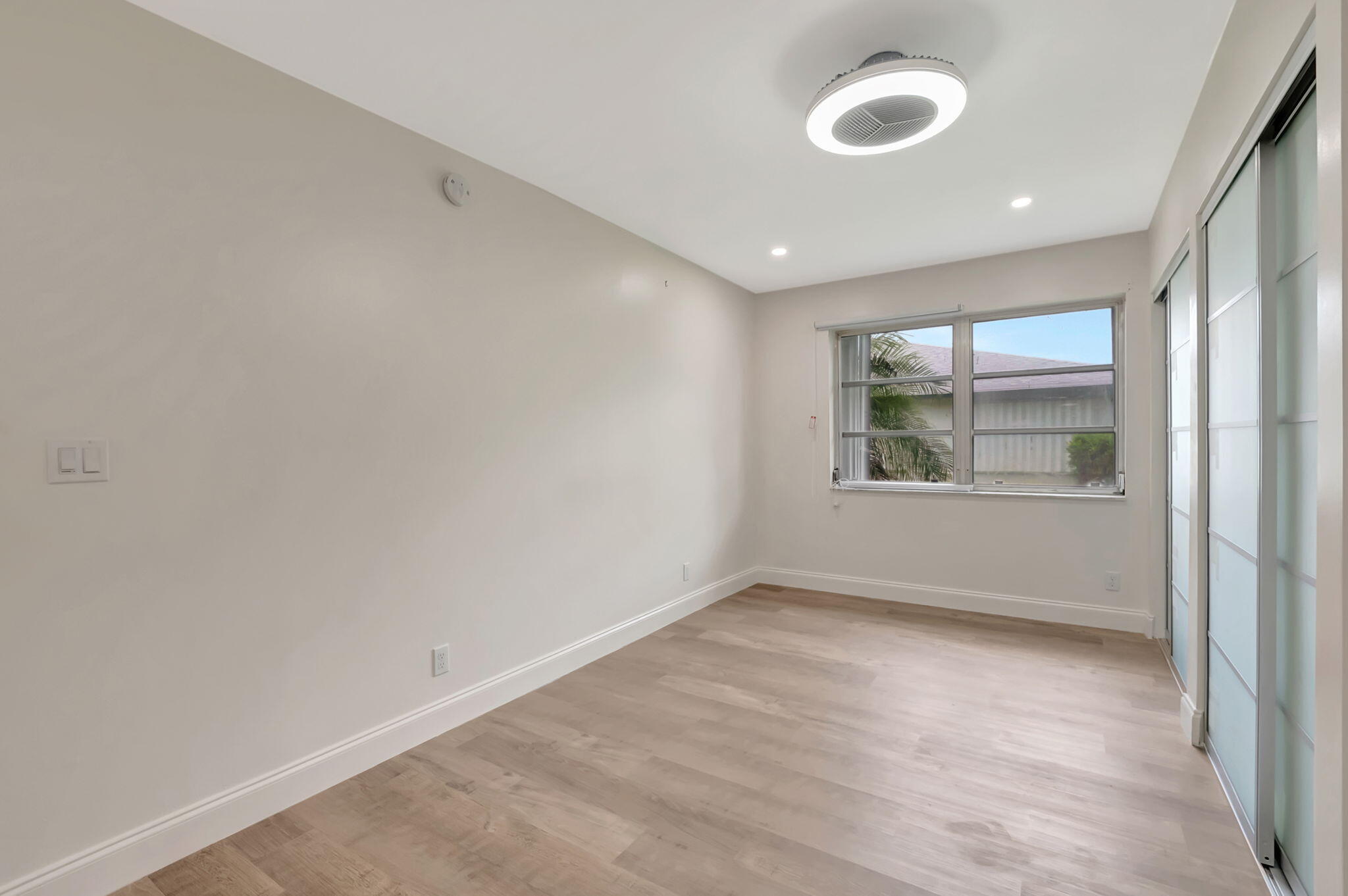 1217 South Drive Way, Unit A Delray Beach, FL 33445 - Photo 22 of 27 an empty room with wooden floor and windows