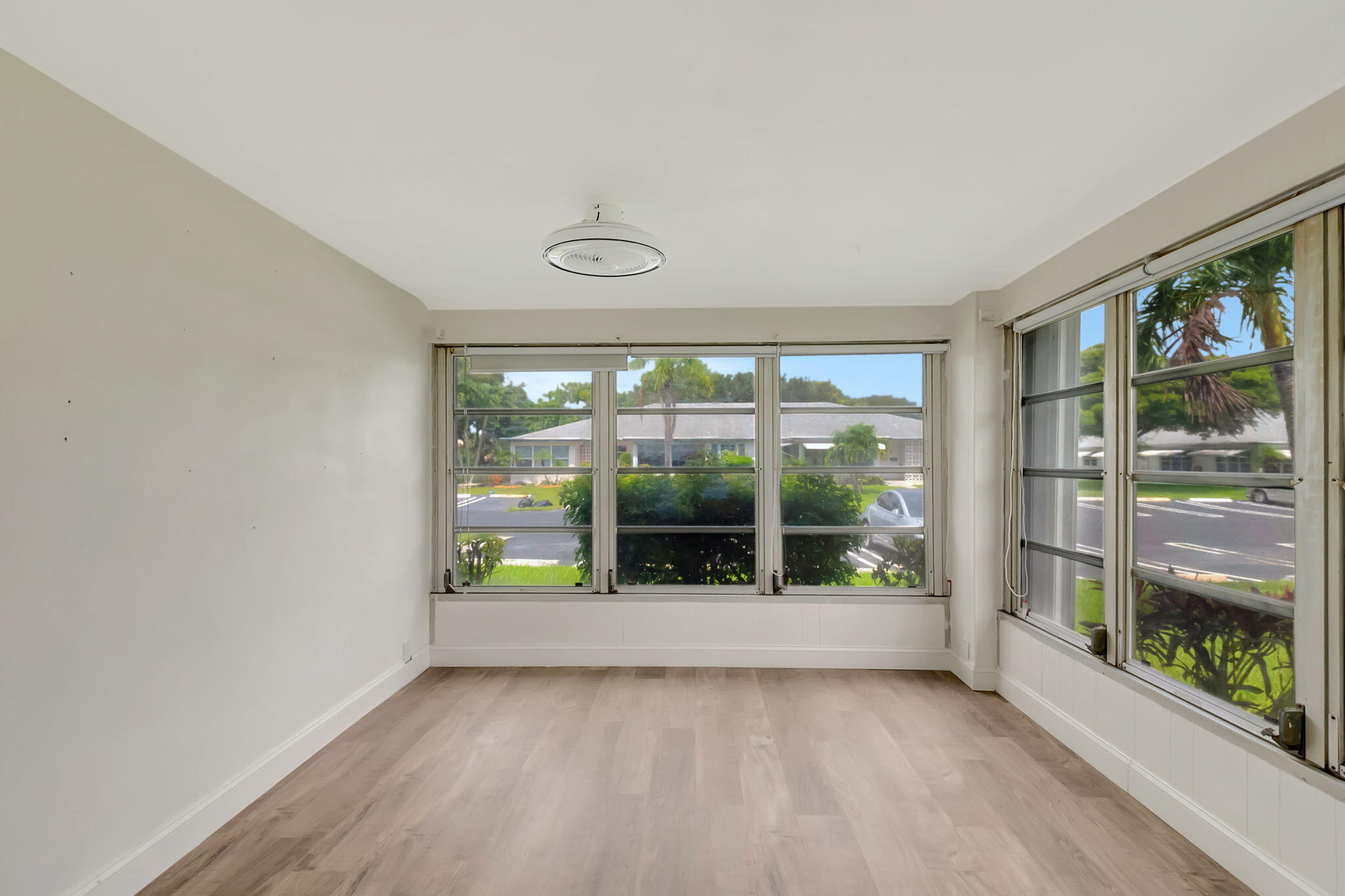 1217 South Drive Way, Unit A Delray Beach, FL 33445 - Photo 8 of 27 an empty room with wooden floor and windows