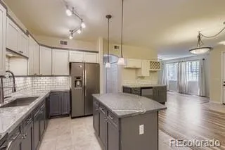 a kitchen with stainless steel appliances granite countertop a sink refrigerator and cabinets