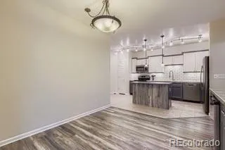 a kitchen with stainless steel appliances granite countertop a sink a stove and a refrigerator