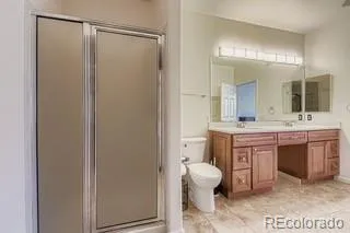 a bathroom with a double vanity sink mirror and toilet