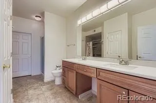 a spacious bathroom with a granite countertop sink a toilet and a mirror