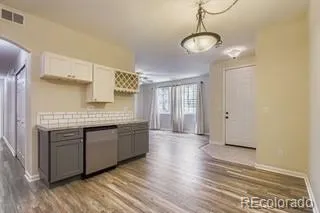 a kitchen with stainless steel appliances granite countertop a sink a stove and a wooden floors