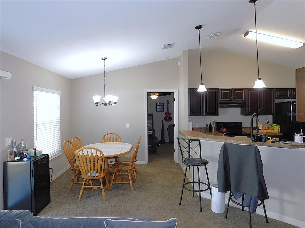 17477 Southwest 36th Terrace Ocala, FL 34473 - Photo 12 of 47 a dining room with furniture a chandelier and window