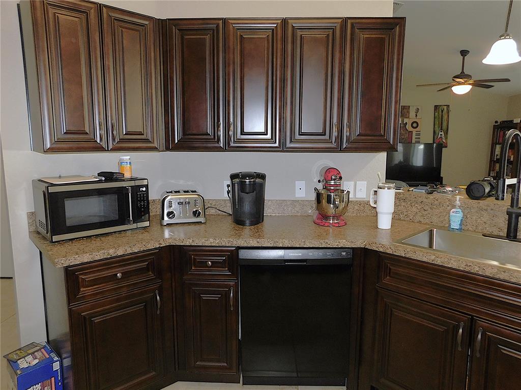 17477 Southwest 36th Terrace Ocala, FL 34473 - Photo 15 of 47 a kitchen with stainless steel appliances granite countertop a sink dishwasher stove and cabinets with wooden floor