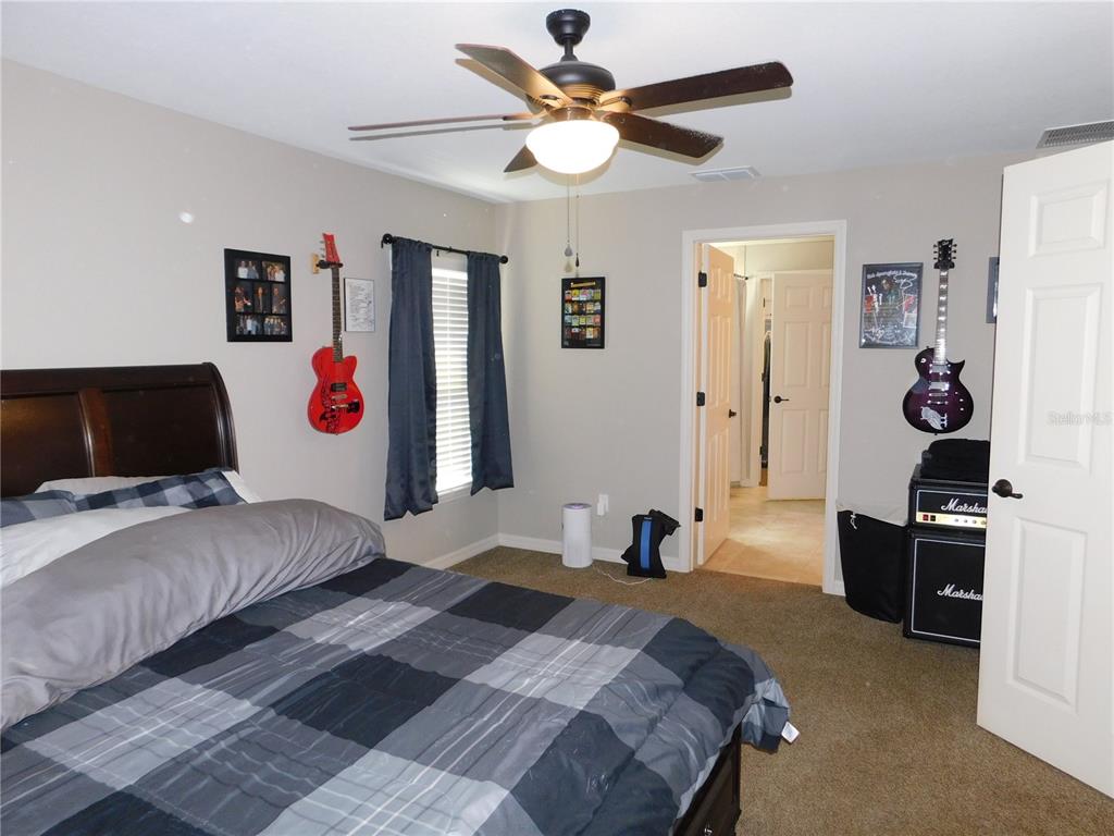 17477 Southwest 36th Terrace Ocala, FL 34473 - Photo 22 of 47 a bedroom with a bed and a chandelier