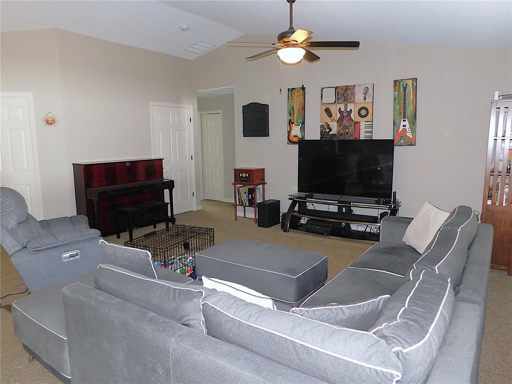 17477 Southwest 36th Terrace Ocala, FL 34473 - Photo 10 of 47 a living room with furniture and a flat screen tv