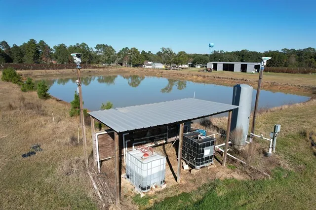 aerial view of a house with pool and lake view