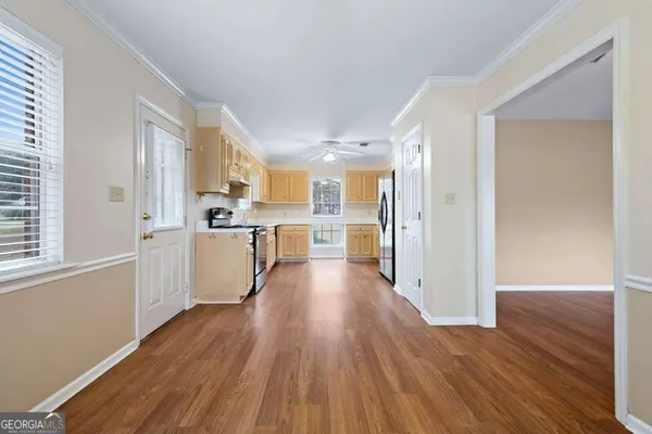 a view of kitchen with wooden floor and electronic appliances