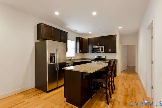 a kitchen with stainless steel appliances granite countertop refrigerator stove microwave and sink