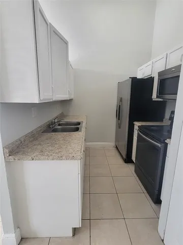 a kitchen with granite countertop a refrigerator and a stove