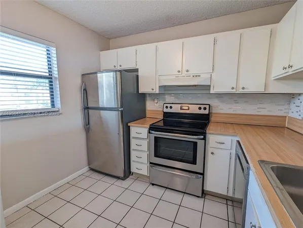 a kitchen with cabinets and steel stainless steel appliances