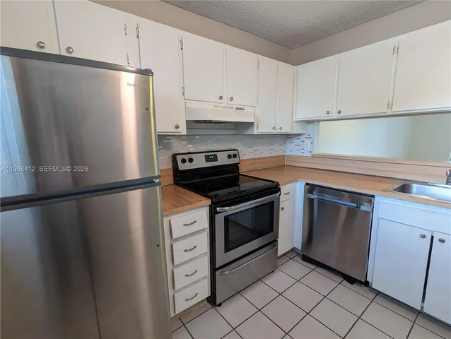 a kitchen with cabinets and stainless steel appliances