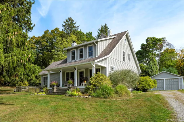 a front view of a house with a garden and trees