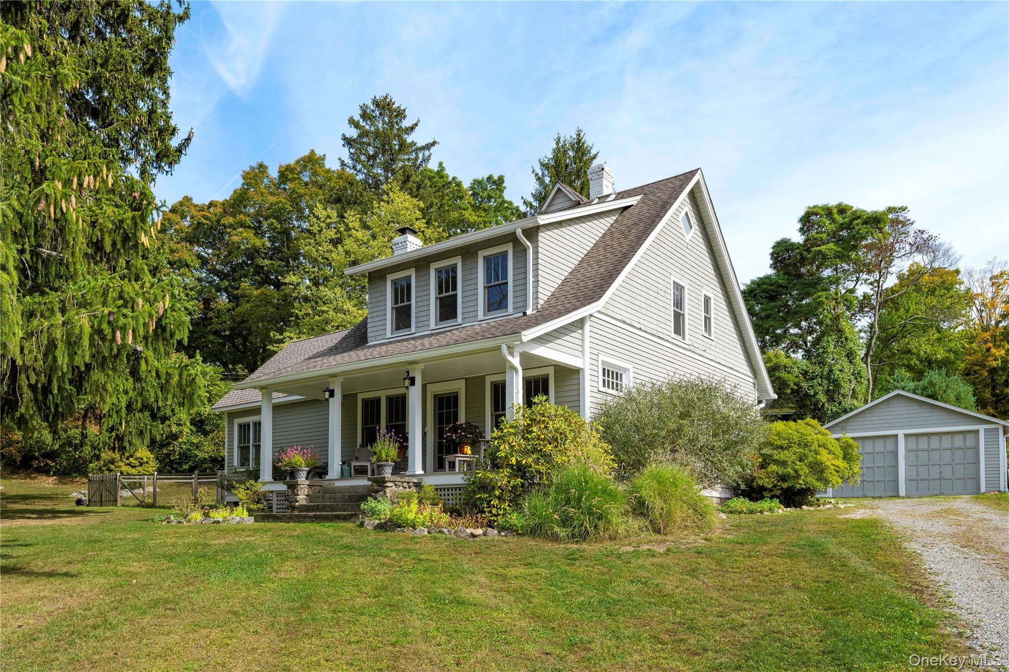 a front view of a house with a garden and trees