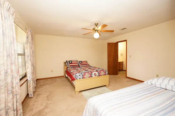 a spacious bedroom with a bed and a chandelier