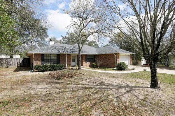 a front view of a house with yard and trees