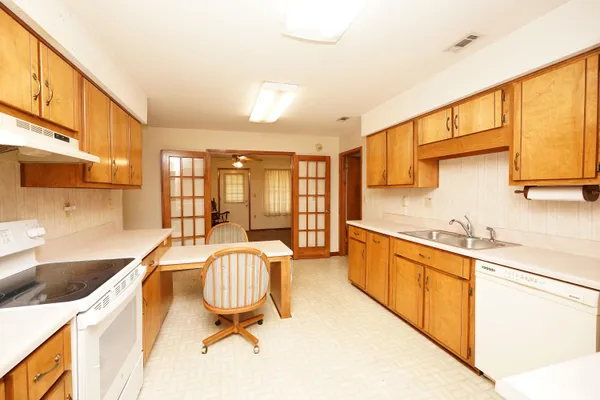 a large white kitchen with a large window