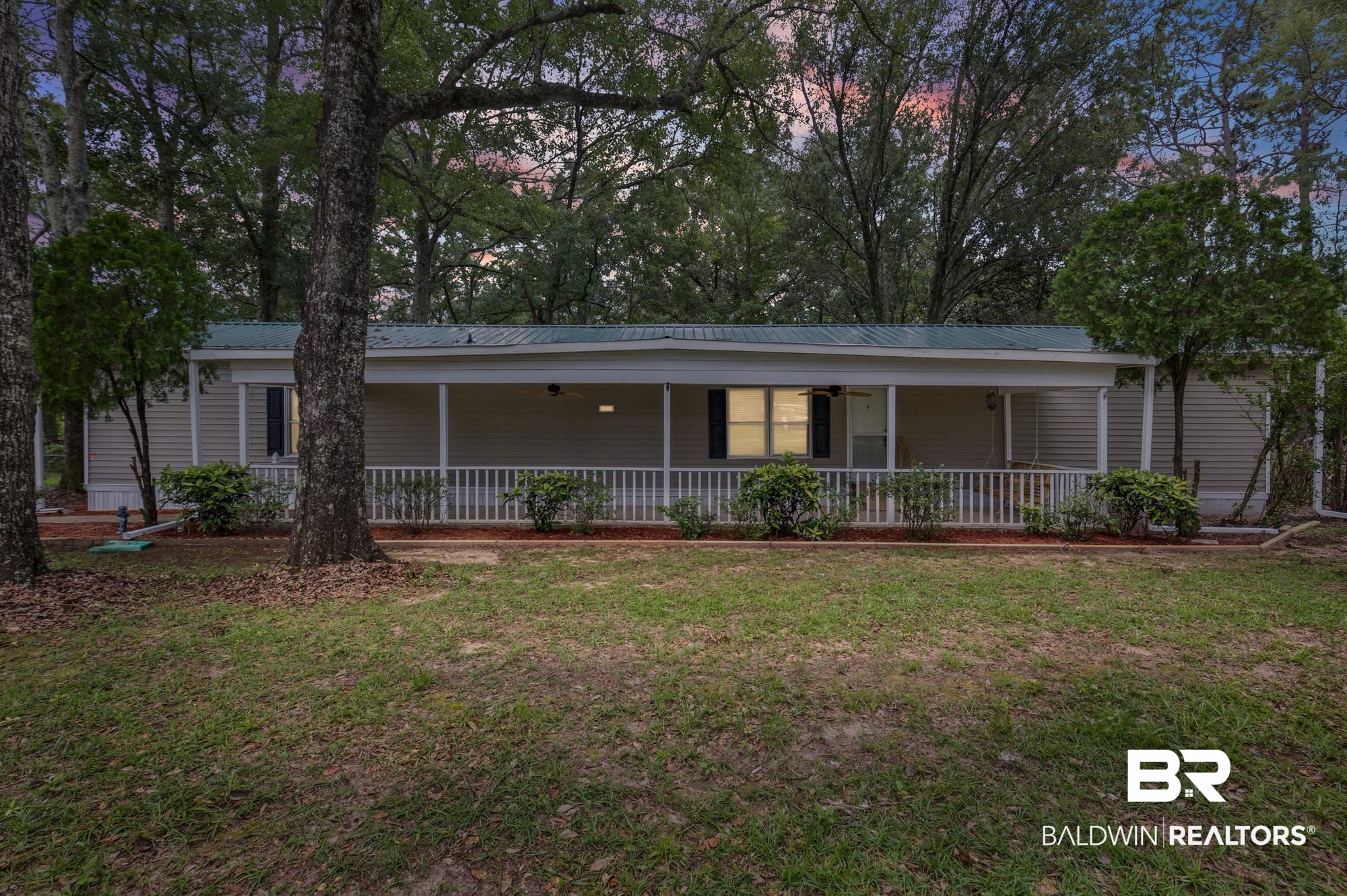 8675 Hunters Pointe Drive North Theodore, AL 36582 - Photo 1 of 20 Single-story residence featuring light-colored siding and a green metal roof