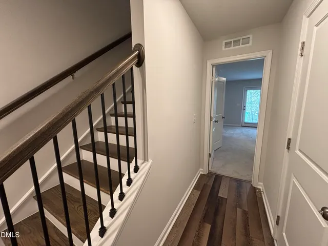 a view of a hallway with wooden floor and staircase