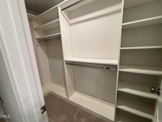 an empty room with closet and windows