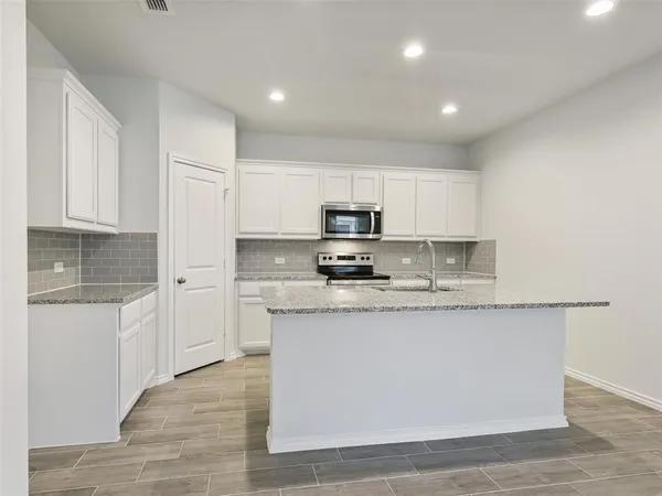 a kitchen with stainless steel appliances granite countertop a stove a sink and a refrigerator