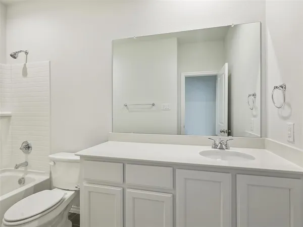a bathroom with a sink toilet vanity and shower