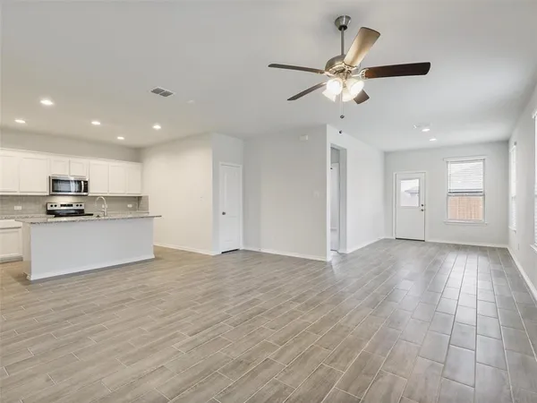 a view of kitchen with granite countertop cabinets and window