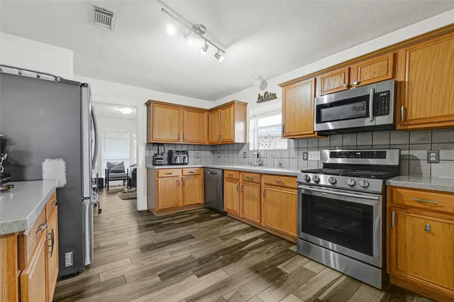 a kitchen with stainless steel appliances a stove sink and microwave