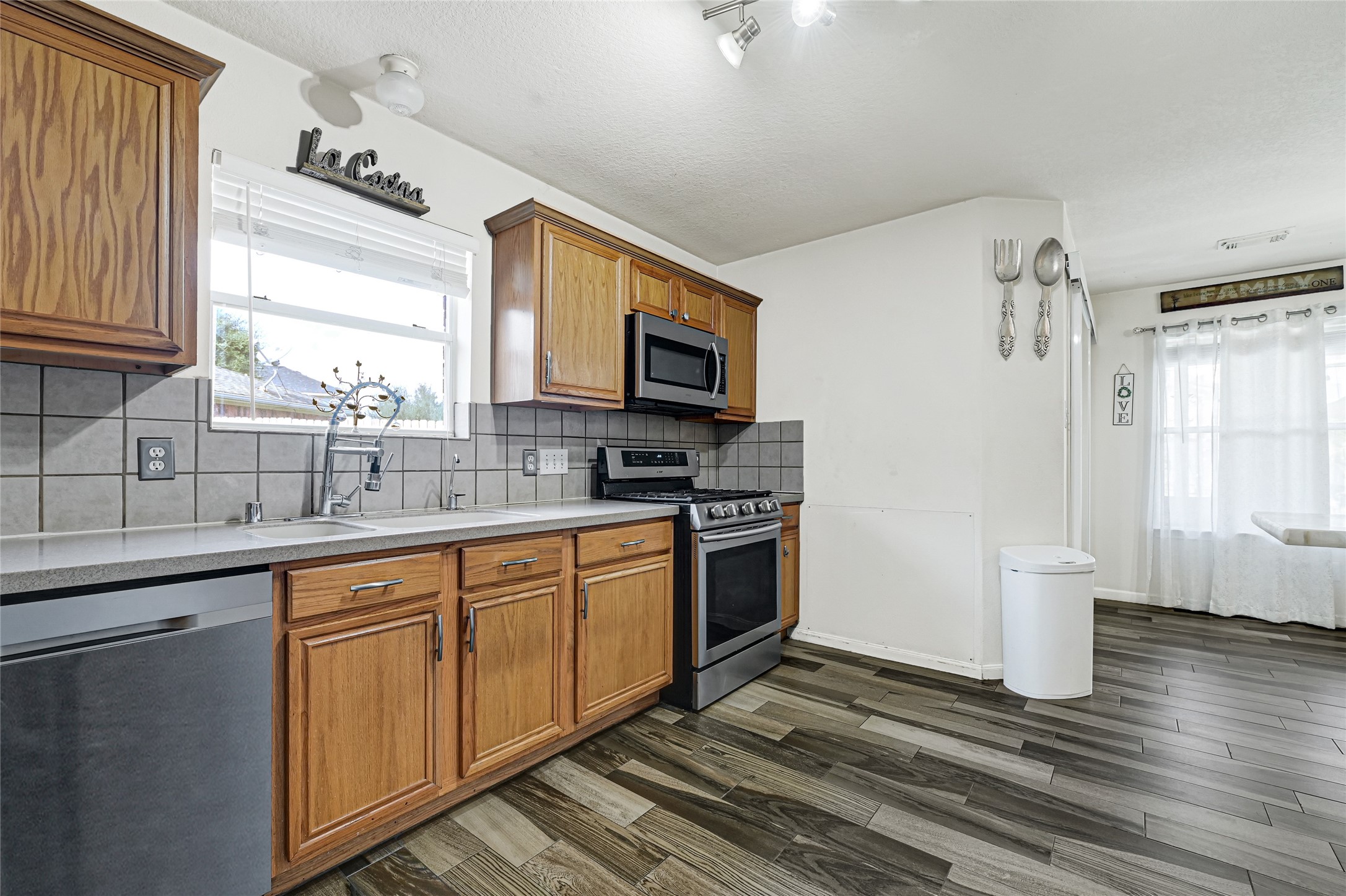 2527 Spring Lily Court Spring, TX 77373 - Photo 12 of 31 a kitchen with stainless steel appliances a stove sink and microwave