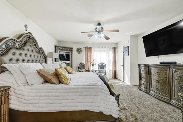 a bedroom with a bed a chandelier with a dresser