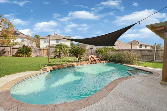 a view of a big yard with plants and a large tree