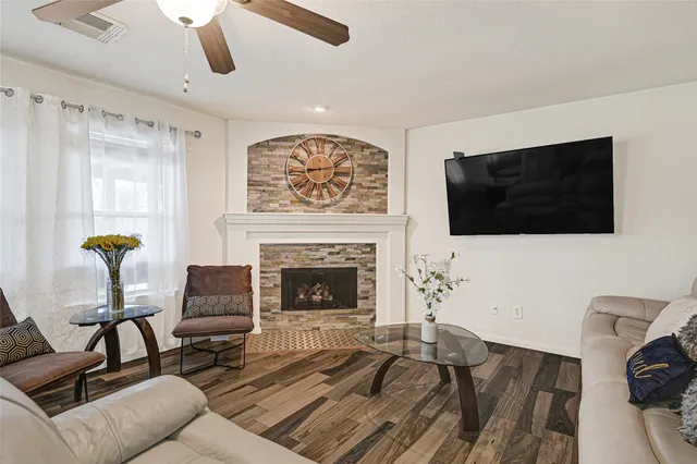 a living room with furniture a flat screen tv and a fireplace